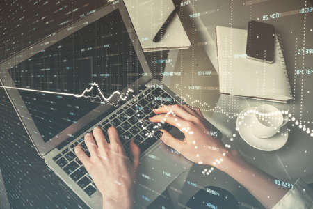 Double exposure of woman hands typing on computer and forex chart hologram drawing. Stock market...