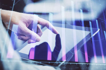 Multi exposure of man's hands holding and using a phone and financial chart drawing. Market analysis...