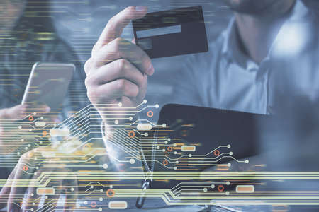 Double exposure of man and woman on-line shopping holding a credit card and data theme hologram...
