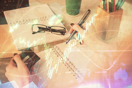 Multi exposure of woman on-line shopping holding a credit card and financial graph drawing. Stock market E-commerce concept.の写真素材