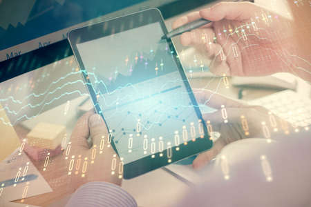 Double exposure of man's hands holding and using a phone and financial chart drawing. Market...