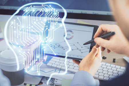 Double exposure of man's hand holding and using a digital device and brain hologram drawing. Data...
