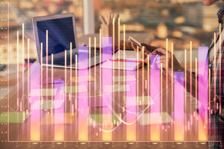 Double exposure of woman hands working on computer and forex graph hologram drawing. Financial...