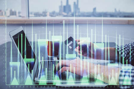 Double exposure of man hands holding a credit card and Forex graph drawing. Stock trading and digital fintech in Internet E-commerce concept.の写真素材