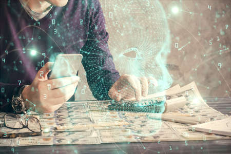 Double exposure of man's hand holding and using a digital device and brain hologram drawing. Data concept.の写真素材