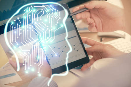 Double exposure of man's hand holding and using a digital device and brain hologram drawing. Data...