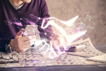 Double exposure of man's hands holding and using a digital device and handshake drawing. Partnership...