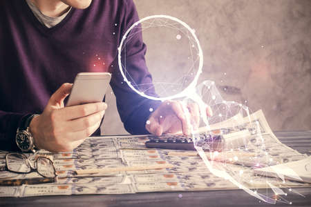 Double exposure of man's hands holding and using a mobile device and creative hologram drawing.の写真素材