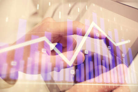 Multi exposure of man's hands holding and using a phone and financial chart drawing. Market analysis...