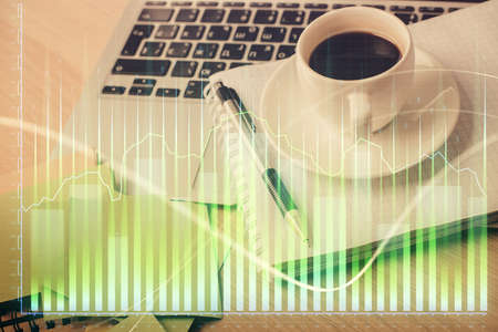 Double exposure of forex chart drawing and desktop with coffee and items on table background. Concept of financial market tradingの写真素材