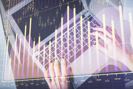 Double exposure of woman hands working on computer and forex chart hologram drawing. Top View....