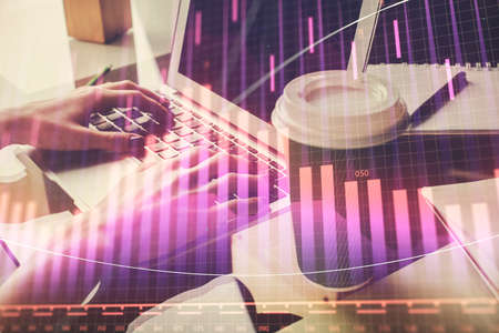 Double exposure of woman hands typing on computer and forex chart hologram drawing. Stock market...