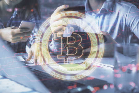 Double exposure of man and woman on-line shopping holding a credit card and crypto theme hologram...