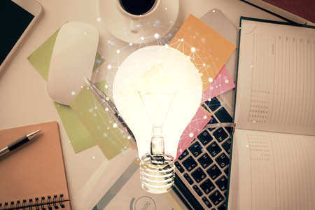 Bulb drawing over computer on the desktop background. Top view. Double exposure. Idea concept.の写真素材