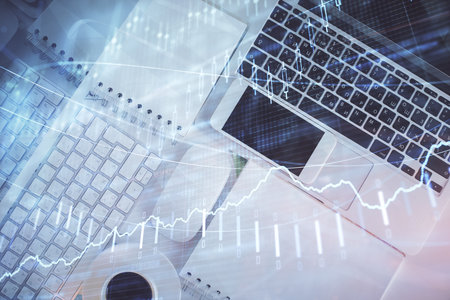 Financial market graph and top view computer on the desktop background. Multi exposure. Investment...