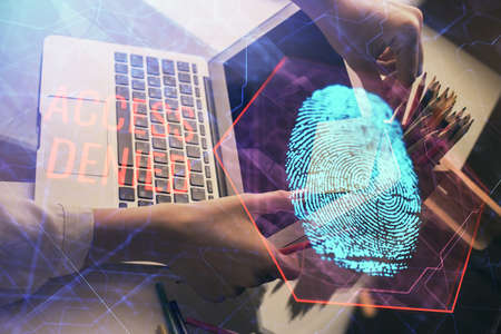 Double exposure of woman hands typing on computer and fingerprint drawing. Security concept.
