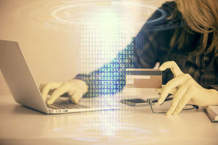 Double exposure of woman on-line shopping holding a credit card and data theme hologram drawing....
