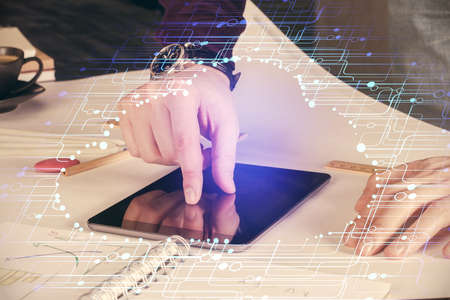 Double exposure of man's hand holding and using a digital device and data theme drawing. Technology...