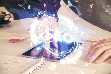 Multi exposure of man's hands holding and using a digital device and seo drawing. search...