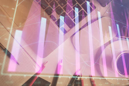 Double exposure of financial chart drawing over table background with computer. Concept of research...