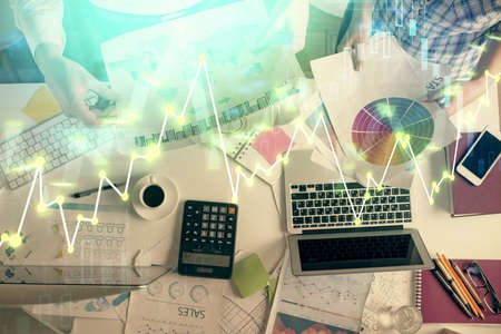 Double exposure of man and woman working together and financial chart hologram drawing. market...