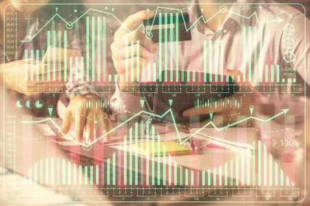 Double exposure of man and woman on-line shopping holding a credit card and forex graph hologram drawing. Stock market E-commerce pay on-line concept.の写真素材