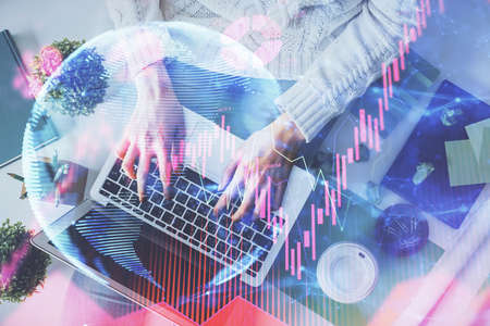 Double exposure of woman hands working on computer and financial theme hologram drawing. Top View....