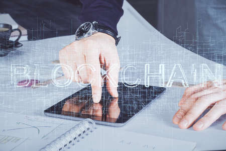 Double exposure of man's hands holding and using a phone and crypto currency blockchain theme drawing.の写真素材
