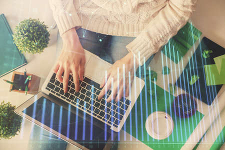 Double exposure of woman hands working on computer and forex chart hologram drawing. Top View....