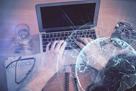 Double exposure of man's hands typing over computer keyboard and social network theme hologram drawing. Top view. People connection web concept.の写真素材