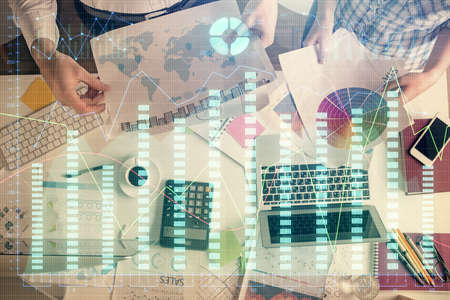 Double exposure of man and woman working together and financial chart hologram drawing. market...