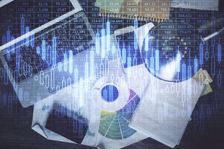 Financial market graph and top view computer on the desktop background. Multi exposure. Investment...