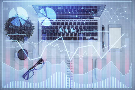 Multi exposure of forex chart drawing over table background with computer. Concept of financial...