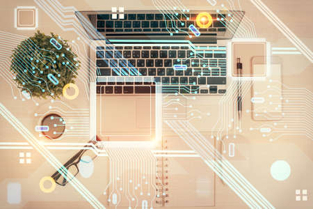 Double exposure of data drawing hologram over topview of study desk background with computer....