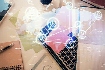 Social network hologram drawings over computer on the desktop background. Top view. Multi exposure. Concept of people connection.の写真素材