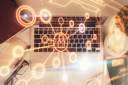 Social network hologram drawings over computer on the desktop background. Top view. Double exposure.