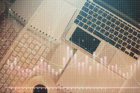 Financial market graph and top view computer on the desktop background. Multi exposure. Investment...