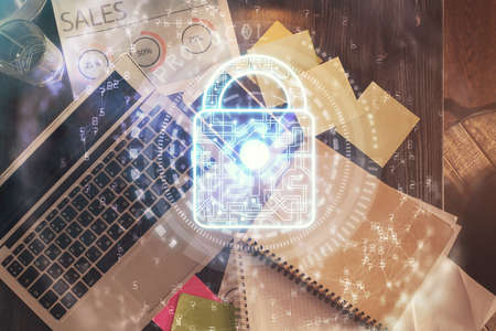 Double exposure of lock hologram drawing over study table background with computer. Concept of data security. Top view.の写真素材