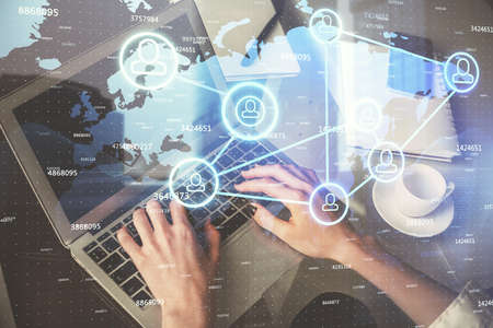 Double exposure of woman hands typing on computer and social network theme hologram drawing. People...