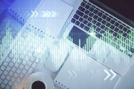 Financial market graph and top view computer on the desktop background. Multi exposure. Investment...