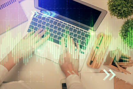 Double exposure of woman hands working on computer and forex chart hologram drawing. Top View....