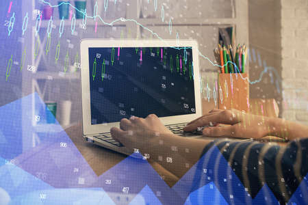 Double exposure of woman hands typing on computer and forex chart hologram drawing. Stock market...