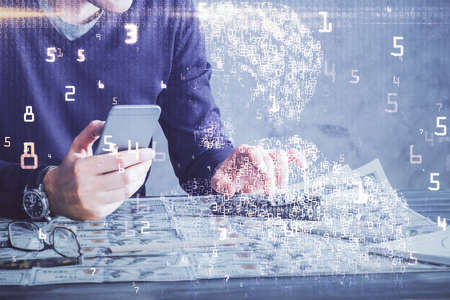 Double exposure of man's hands holding and using a digital device and tech theme hologram drawing....