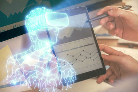 Double exposure of man's hands holding and using a digital device and AR glasses drawing. Virtual reality concept.の写真素材