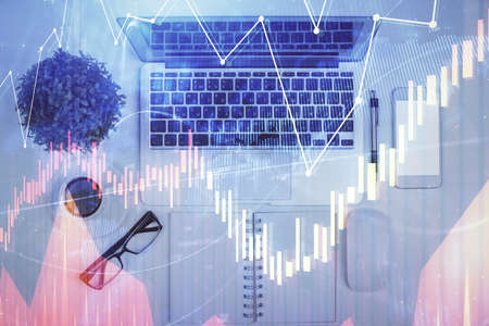 Multi exposure of forex chart drawing over table background with computer. Concept of financial...