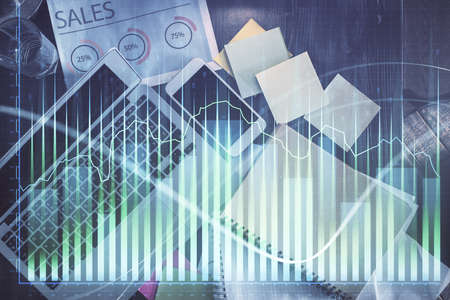 Financial market graph and top view computer on the desktop background. Multi exposure. Investment...
