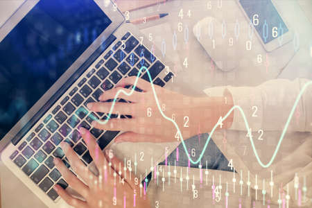 Double exposure of woman hands working on computer and forex chart hologram drawing. Top View....