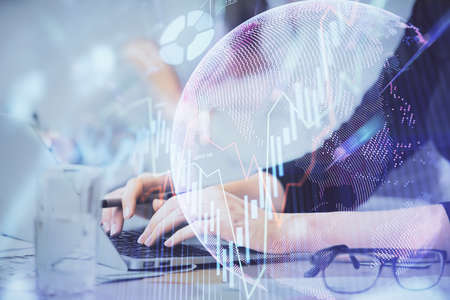 Multi exposure of woman hands typing on computer and financial graph hologram drawing. Stock market...