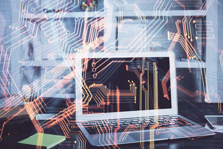 Computer on desktop in office with technology theme hologram. Multi exposure. Tech concept.の写真素材