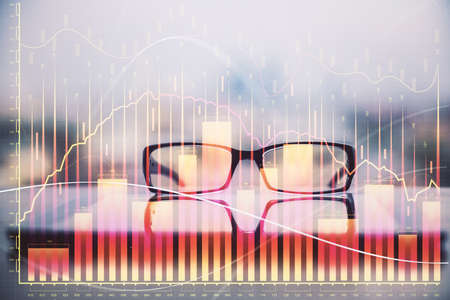 Financial graph hologram with glasses on the table background. Concept of business. Double exposure.の写真素材